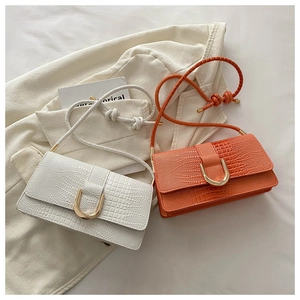 Détail du sac bandoulière gaufré crocodile avec boucle en U dorée et bandoulière