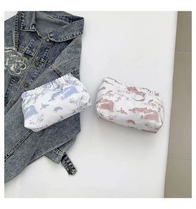 Detail of pink and blue landscape print drawstring pouches on a denim jacket
