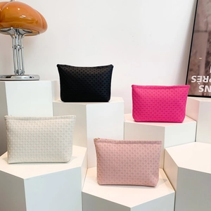 Minimalist woven envelope clutch bags in black, pink, and white on a hexagon display