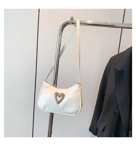 Close-up of a white PU leather baguette bag with a silver rhinestone heart-shaped buckle