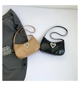 Detail of heart rhinestone buckle on black and khaki moon-shaped shoulder bags