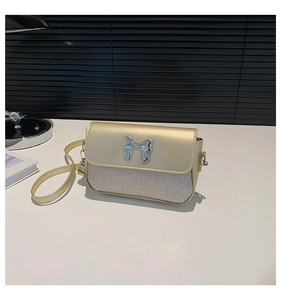 Detailansicht der champagnergoldenen und silbernen gewebten Tasche mit Metallschleife