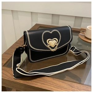 Detail of black PU leather crossbody bag with heart-shaped metal buckle and wide strap