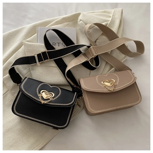 Detail of elegant small square bags with golden heart clasps and wide fabric straps