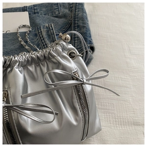 Détail du sac seau métallisé argenté avec cordon de serrage et nœud décoratif