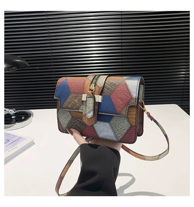 Close-up of geometric patchwork small square bag with textured crocodile pattern