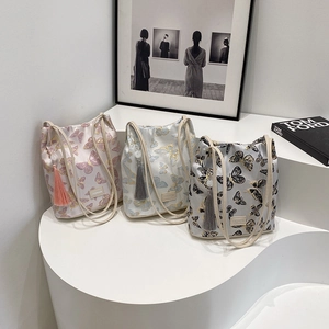Trois sacs à bandoulière en jacquard papillon rose blanc et bleu sur un présentoir chic