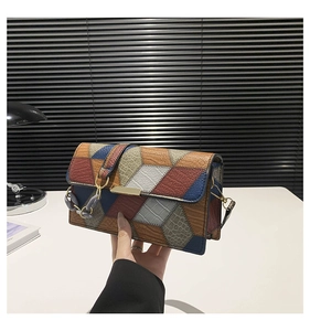 Détail du sac à main color-block montrant les textures crocodile et palmier et boucle d'or