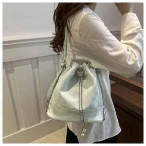 Détail du sac seau vert menthe avec fermoir papillon en métal et cordon perlé
