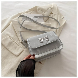 Détail du sac bandoulière gris clair motif marbre avec boucle papillon argentée