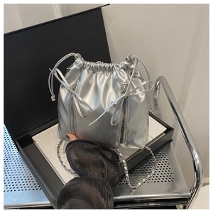 Vue détaillée du sac seau argenté métallisé avec cordon et chaîne dans un coffret