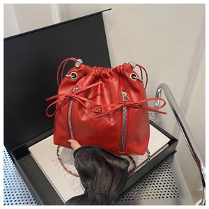 Sac seau rouge à cordon avec fermetures éclair et nœud sur une boîte cadeau