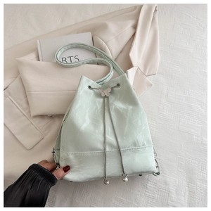 Détail du sac seau vert menthe avec cuir texturé marbré et cordon de serrage papillon