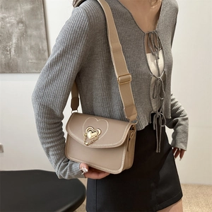 Beige faux leather crossbody bag with heart buckle and stitched embroidery pattern