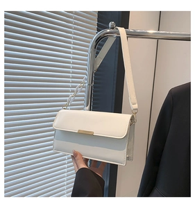 Détail du sac bandoulière en cuir PU blanc avec boucle dorée et chaîne en résine