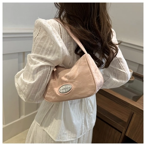 Close-up of pink textured nylon underarm bag featuring a silver oval metal brand logo