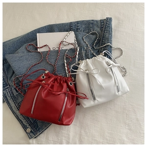 Détail de sacs seaux en cuir PU rouge et blanc avec cordon et bandoulière chaîne