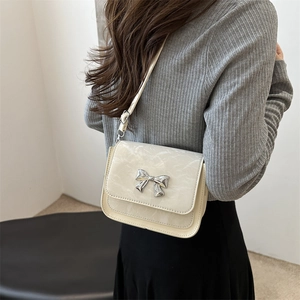 Sac bandoulière élégant blanc crème avec boucle papillon argentée et texture