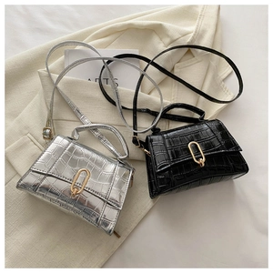 Detail of stone textured handbags with oval gold hardware in black and silver
