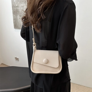 Minimalistische beige Umhängetasche aus Kunstleder mit Pfirsichhaut-Narbung an Model