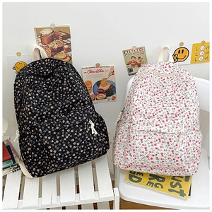 Detail of floral canvas backpacks featuring main compartments and front zip pockets