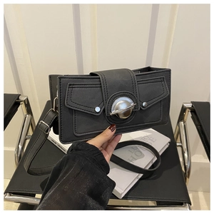 Close-up of black rectangular shoulder bag with silver planet buckle and buckle pockets