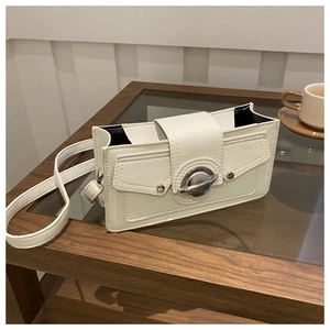 Close-up of a white rectangular handbag featuring a silver planet-shaped metal buckle