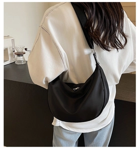 Detail of black nylon crescent hobo bag shown on model highlighting size and daily style