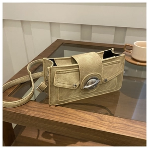Retro khaki canvas crossbody bag with silver planet metal buckle on a wooden table