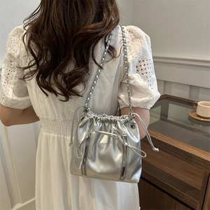 Sac seau en cuir argenté avec cordon de serrage, chaîne métallique et détails double zip