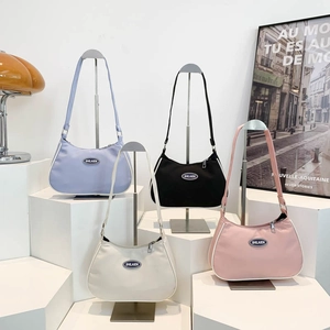 Chic nylon crescent shoulder bags in multiple colors displayed on minimalist stands