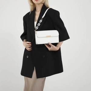 Sac bandoulière blanc en similicuir avec boucle dorée et chaîne en résine sur modèle