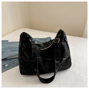 Detail of black wrinkled texture tote bag with gold hardware and zipper closure