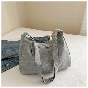 Detail of light grey tote bag featuring textured fabric and adjustable golden metal buckle