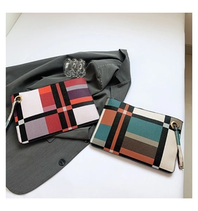 Detail of stylish color-block plaid envelope clutches with canvas fabric and wrist straps