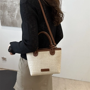 Straw trapezoid bucket bag with brown leather handles for summer beach vacation styling