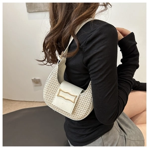 Detail view of woven cream crescent hobo bag with gold buckle on shoulder strap