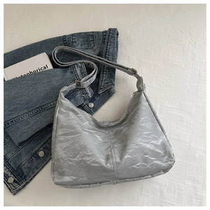 Macro shot of silver hobo bag featuring premium pleated texture and metallic finish