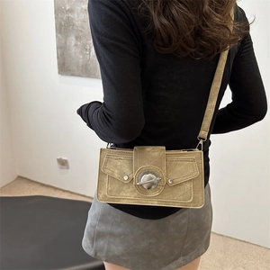 Chic retro khaki shoulder bag with round metal buckle worn by a model in casual setting
