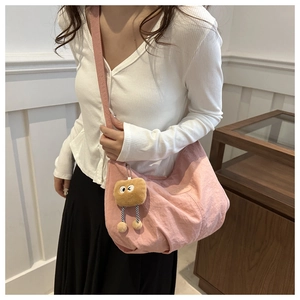 Pink crossbody bag with pleated fabric detail and cute toast plush pendant shown on model