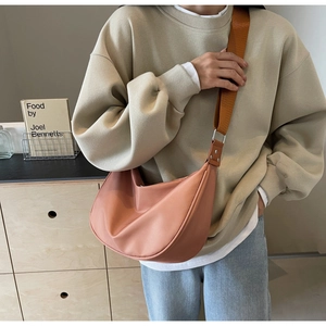 Detail of dusty pink nylon half-moon crossbody bag with wide brown shoulder strap