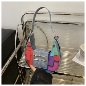 Detail view of woven patchwork crescent bag with vintage metallic buckle and leather strap