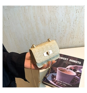 Detailed view of beige straw mini crossbody bag with golden chain and metal turn-lock closure