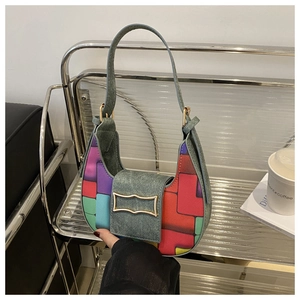 Close-up of multicolored geometric patterned crescent bag with denim fabric and gold buckle