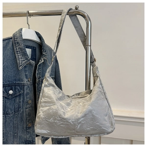 Close-up of silver hobo bag with pleated texture and adjustable strap on a hanger