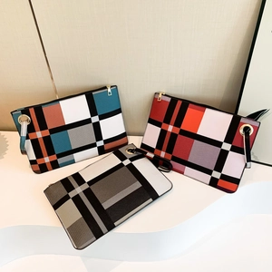 Three stylish plaid clutch bags with minimalist color-block patterns and gold hardware