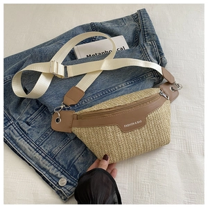 Detail of woven straw bag with brown leather trim and white wide fabric shoulder strap