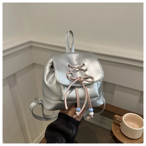 Détail du sac à dos argenté métallisé avec cordon rose et perles décoratives bleues
