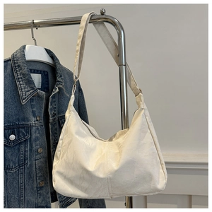 Detail of the cream pleated faux leather texture and wide strap on the large tote bag