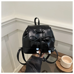 Détail d'un mini sac à dos en cuir PU noir avec nœud de serrage et perles bleues élégantes